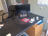 a desk with a computer monitor and a book on it