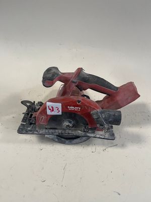 une photo d'une scie circulaire rouge posée sur une surface blanche