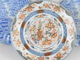 two blue and white plates with flowers and leaves on them
