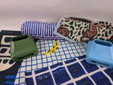 a blue and white towel, a blue and green case, and a blue and white towel on a blue and white checkered blanket