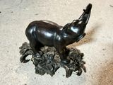 a statue of an elephant standing on a pile of leaves