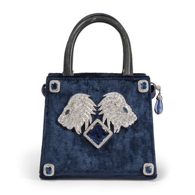a blue handbag with two lions on the front and a heart on the back