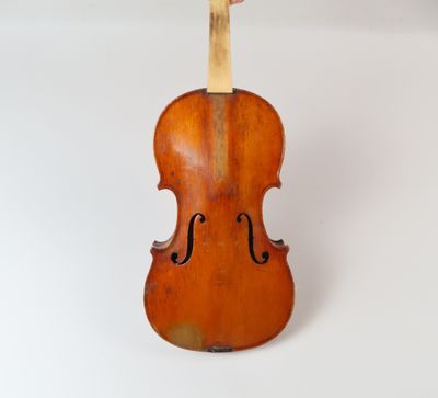 un vieux violon posé sur une surface blanche