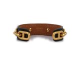 a black and gold leather dog collar with brass hardware on a white background