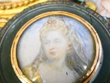 a miniature picture of a woman in a dress on a table