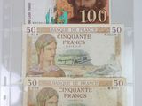 three different bank notes are on display in a glass case