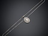 un collier en argent orné d'un motif en spirale sur fond noir