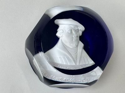 une sculpture en verre représentant un homme coiffé d'un chapeau