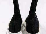 a pair of black and white sneakers on a white surface