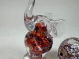 a glass figurine of an elephant and a glass ball
