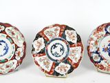 three plates with different designs on them sitting next to each other
