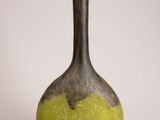 a yellow and black vase sitting on a white surface