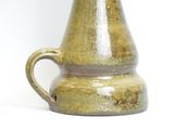 a brown vase that is sitting on a white surface
