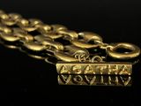 an image of a close up of a gold necklace on a black surface