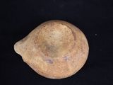 a small piece of pottery sitting on a black surface