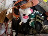 de nombreuses paires de chaussures empilées sur un lit