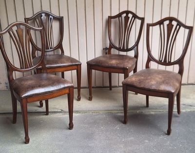 trois chaises en bois placées les unes à côté des autres devant un mur