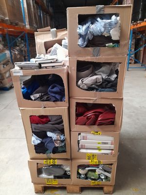 des cartons empilés les uns sur les autres dans un entrepôt rempli de vêtements