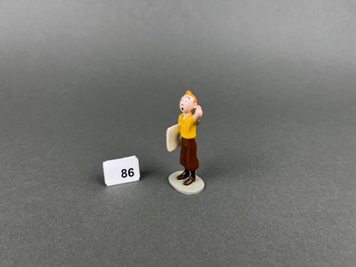 figurine of a man holding a sign with a number in front of him