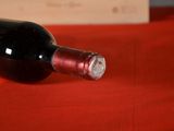 a bottle of wine sitting on a red table cloth