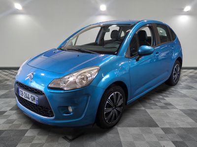 une voiture bleue est garée sur le sol à carreaux d'un garage