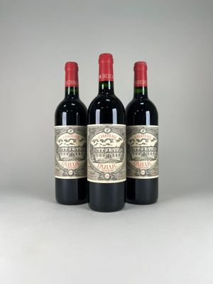 trois bouteilles de vin rouge posées côte à côte sur une table