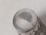 a small silver object on a white surface