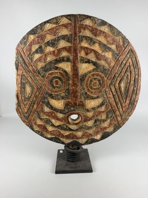 a wooden mask on a stand with a white background