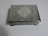 an antique silver box with a design on the lid