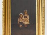 painting of two children in a gold frame with a black background