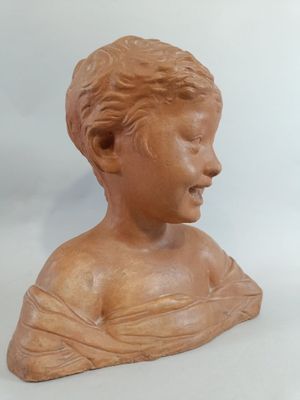 a clay bust of a young boy with his head turned to the side