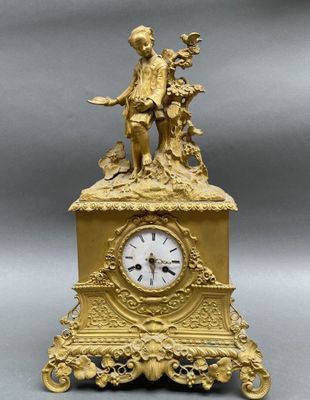une horloge en or surmontée d'une statue