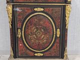 a black and red cabinet with gold trimming and a marble top