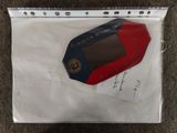 a small red and blue electronic device in a clear bag