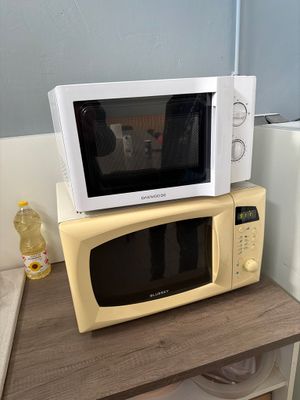 un micro-ondes posé sur un four à micro-ondes