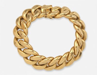 gros plan d'un bracelet en or sur fond blanc