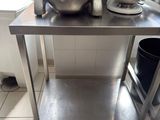 une table en acier inoxydable sur laquelle est posé un mixeur