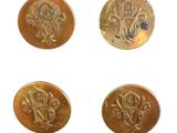 quatre pièces d'or ornées de motifs sur un fond blanc