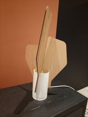 wooden utensils in a white vase on top of a black dresser