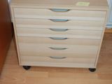 a wooden dresser with three drawers on it in a room