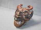 a ceramic sculpture of a man with horns on his head