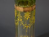 a green glass vase with a gold decoration on it