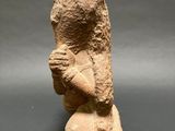 a stone statue of a woman holding a bird in her hands