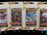 three packs of pokemon trading cards are on display in a package