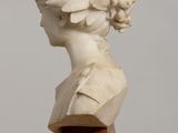 sculpture of a woman ' s head on a wooden base