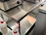 stainless steel counter top in a commercial kitchen with a toaster on top of it