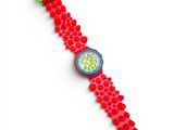 a close up of a red watch with a green band