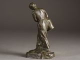 bronze statue of a woman holding a bag