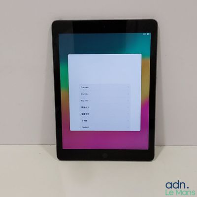 la tablette est posée sur une table blanche avec un arrière-plan coloré