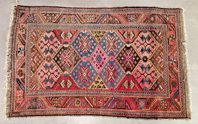 an old rug with a pink and blue design on it